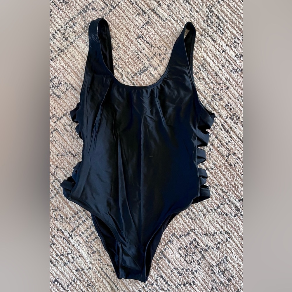 Strappy black one piece bathing suit.